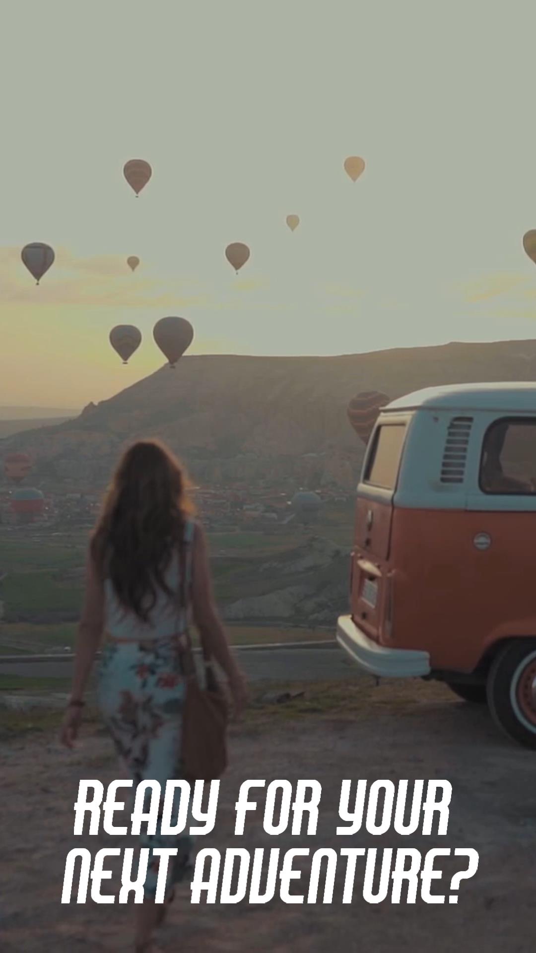 Woman standing in front of van and watchting hot-air balloon festival
